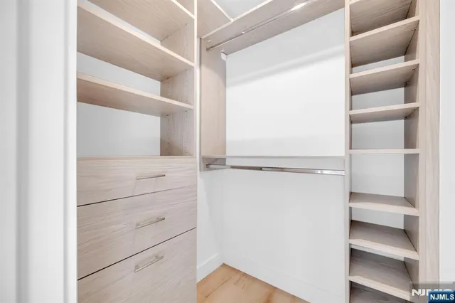 a view of walk in closet with empty racks