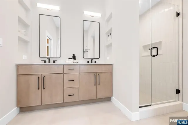 a bathroom with a double vanity sink a mirror and shower