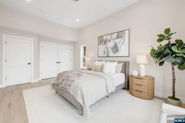 a spacious bedroom with a bed and a plant