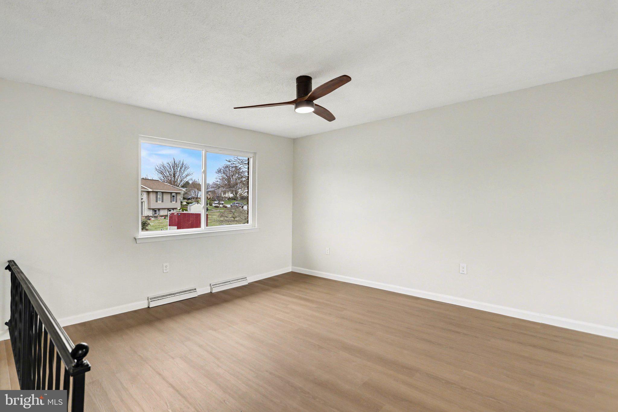 4273 Marlborough Road Dover, PA 17315 - Photo 5 of 29 an empty room with wooden floor ceiling fan and windows