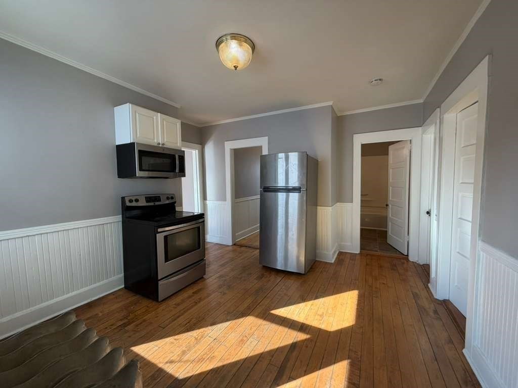 246 Rogers Street, Unit 1 Lowell, MA 01852 - Photo 13 of 17 a kitchen with a refrigerator and a stove top oven