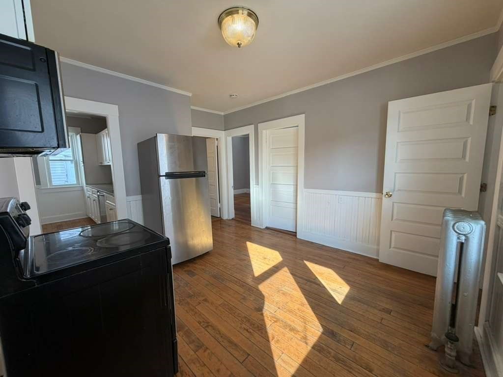 246 Rogers Street, Unit 1 Lowell, MA 01852 - Photo 14 of 17 a kitchen with a refrigerator and wooden floor
