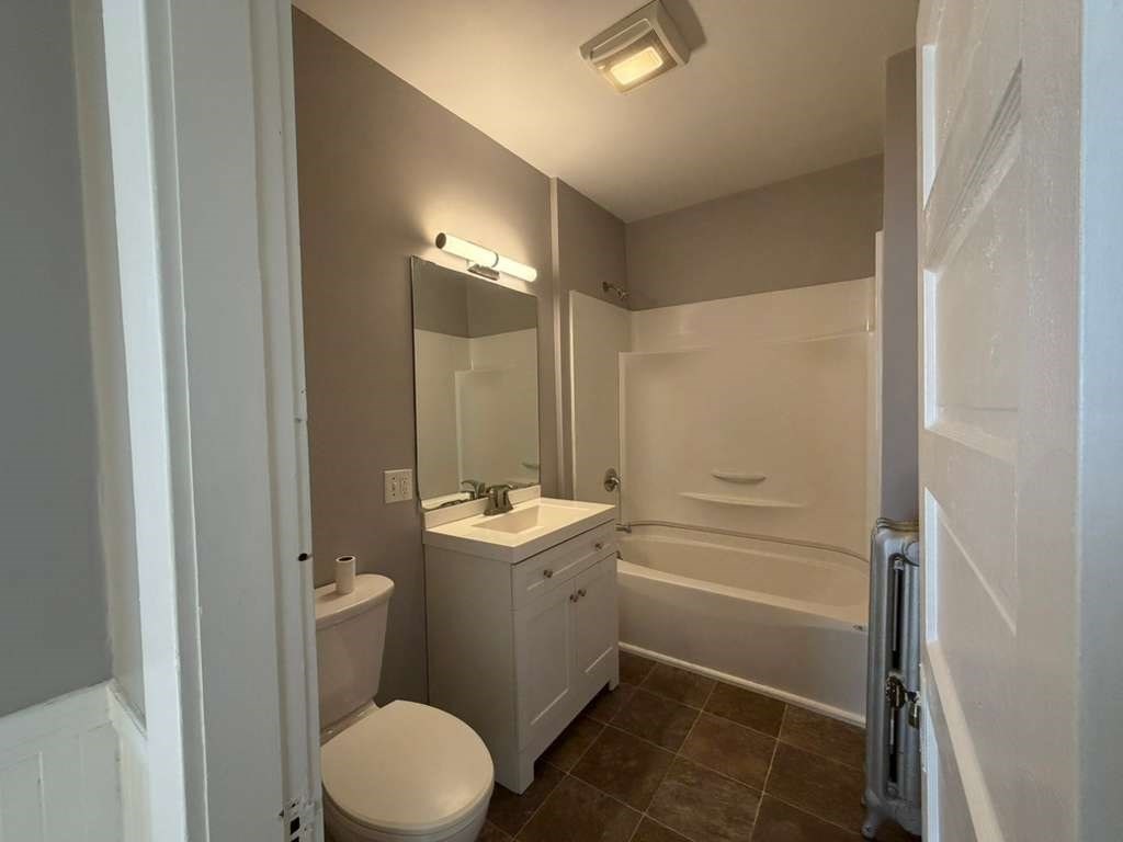 246 Rogers Street, Unit 1 Lowell, MA 01852 - Photo 16 of 17 a bathroom with a granite countertop sink toilet and shower