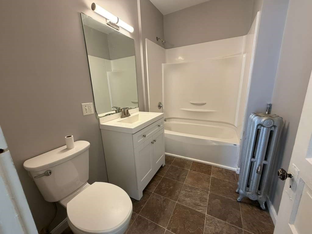 246 Rogers Street, Unit 1 Lowell, MA 01852 - Photo 17 of 17 a bathroom with a sink a toilet and a mirror