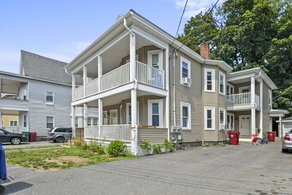 246 Rogers Street, Unit 1 Lowell, MA 01852 - Photo 2 of 17 a front view of a building with a garden and plants