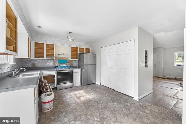 a kitchen with a sink refrigerator and stove