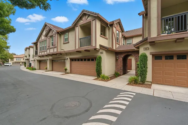 a view of a white house with large windows next to a road