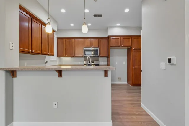 a kitchen with stainless steel appliances granite countertop a refrigerator a sink and a stove