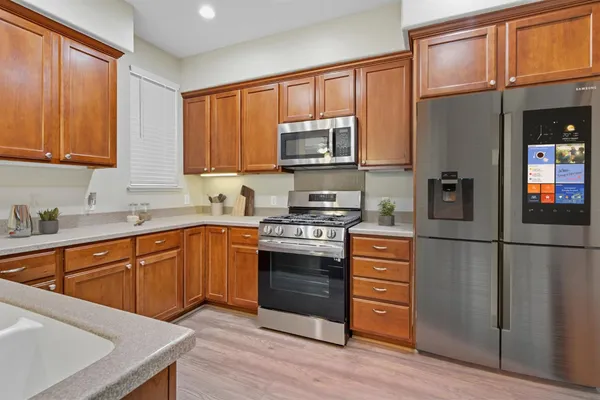 a kitchen with stainless steel appliances granite countertop a refrigerator stove and sink
