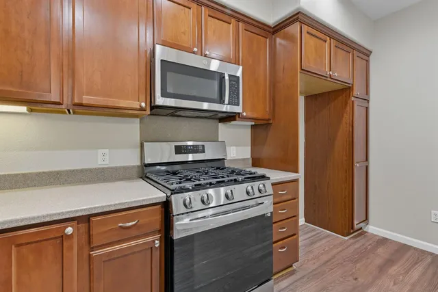 a kitchen with wooden cabinets and a stove top oven