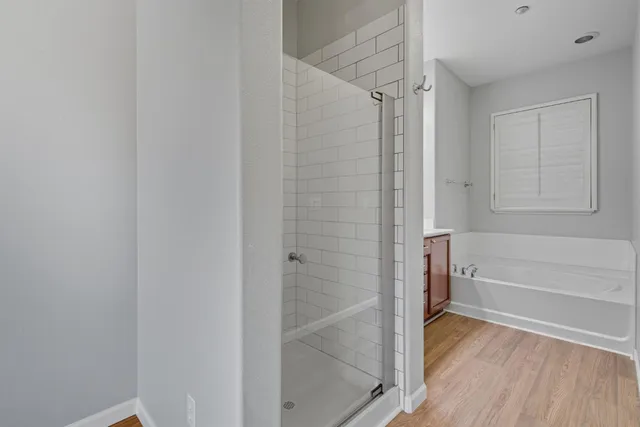 a bathroom with a tub a sink and mirror
