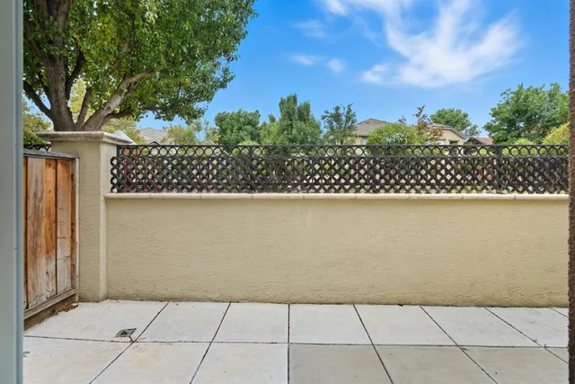 a view of a patio with couple of chairs and a flower pot