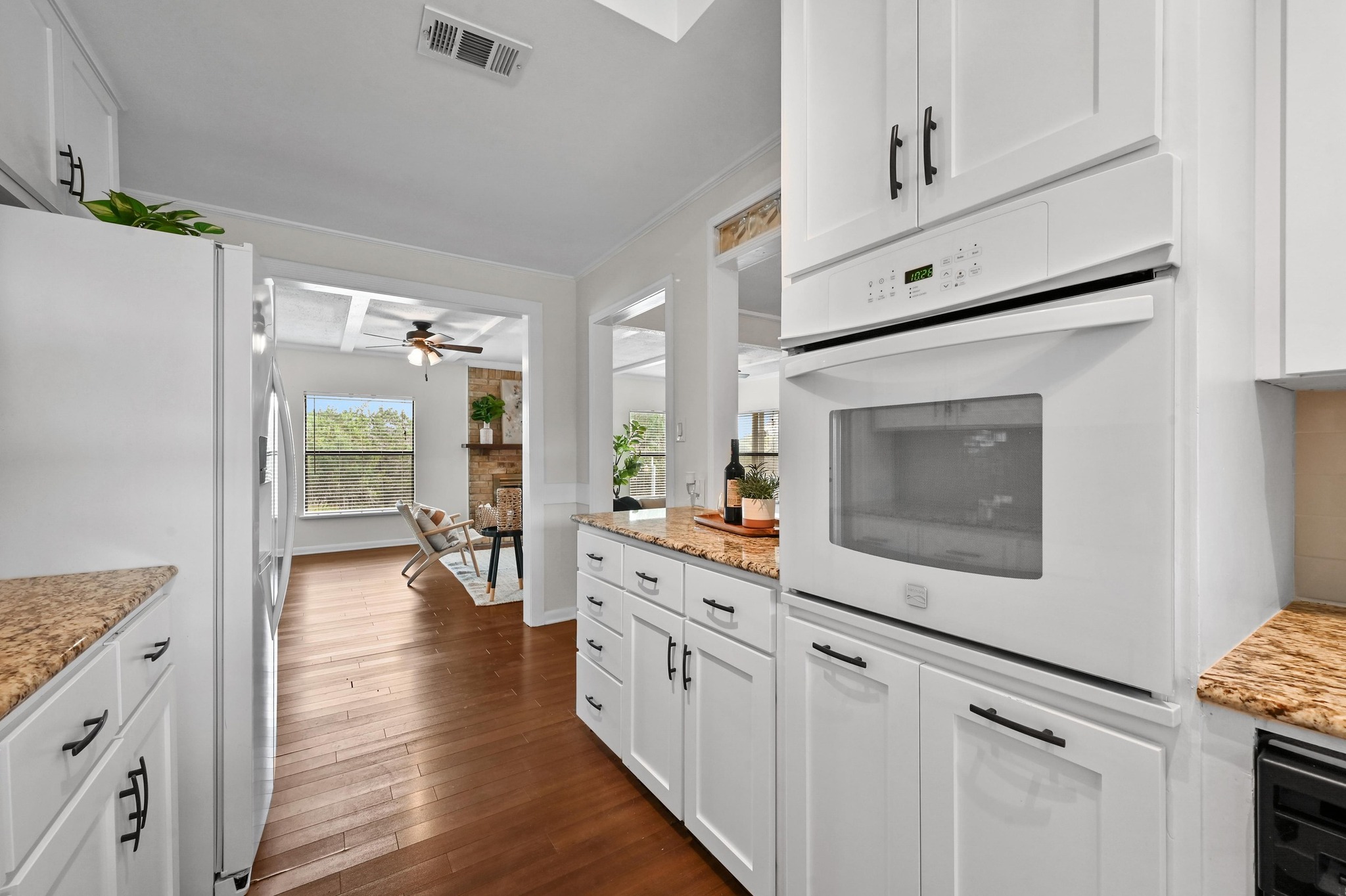 2018 Chaparral Park Road Manchaca, TX 78652 - Photo 10 of 26 Kitchen featuring white appliances, light stone countertops, white cabinetry, and crown molding