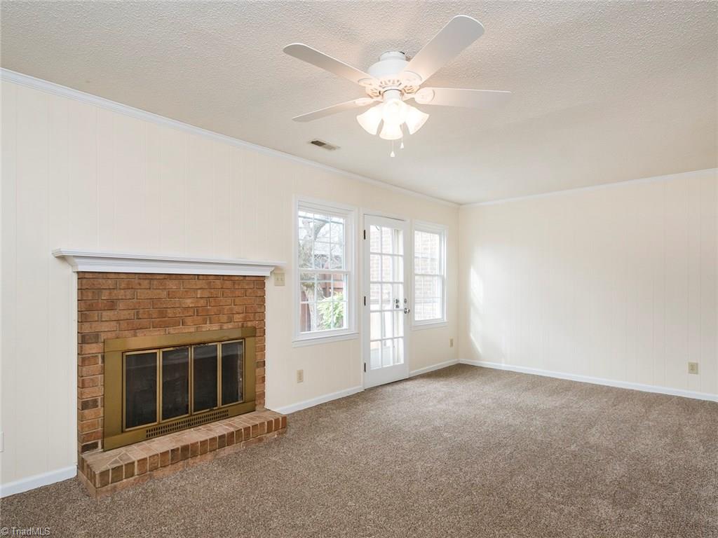 4832 Tower Road, Unit B Greensboro, NC 27410 - Photo 3 of 24 Spacious living room with gas log fireplace and access to the back deck. Notice the ceiling fans.