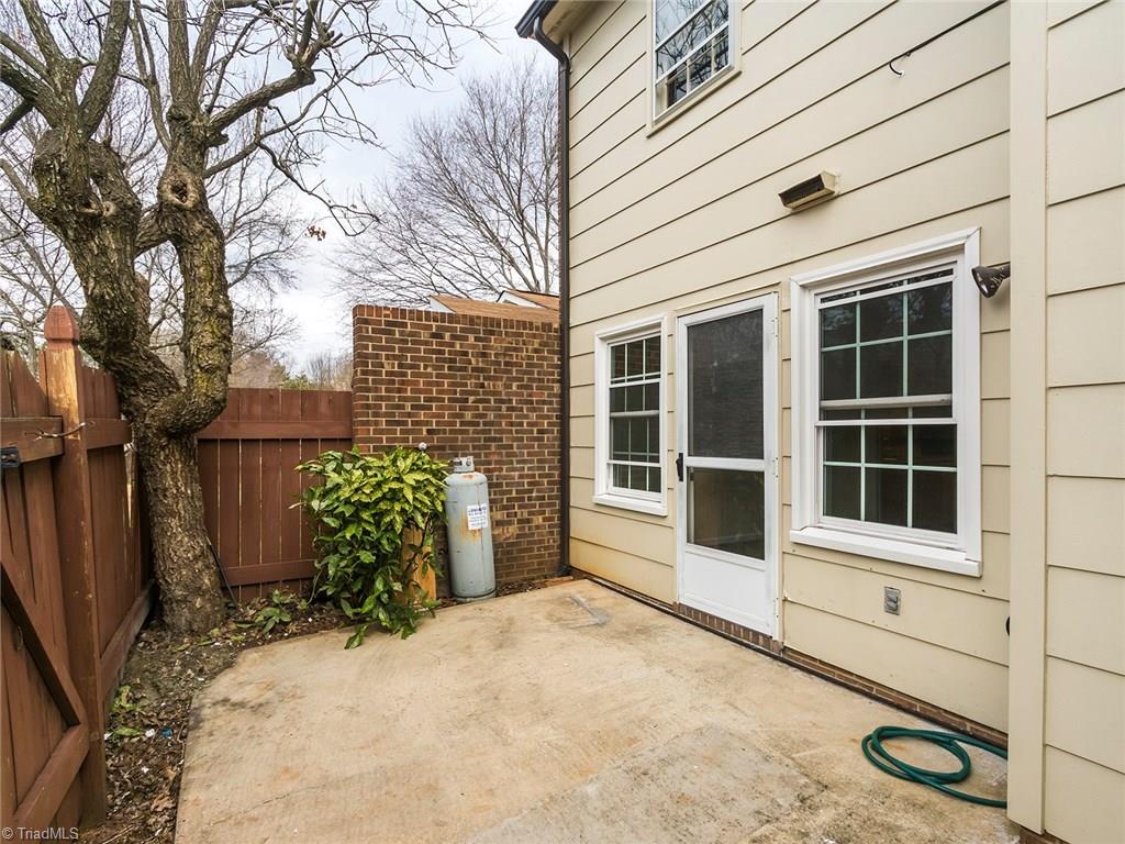 4832 Tower Road, Unit B Greensboro, NC 27410 - Photo 22 of 24 Back patio area with private fence and enough room for table and chairs.