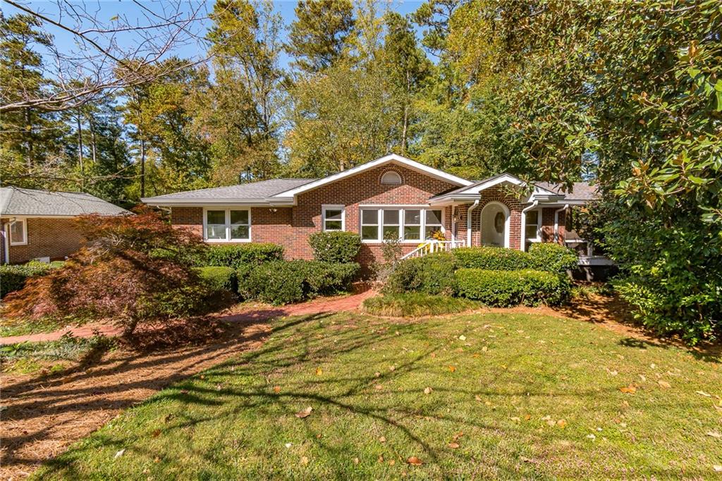 1242 Goodwin Road Northeast Brookhaven, GA 30324 - Photo 1 of 1 a front view of a house with a yard