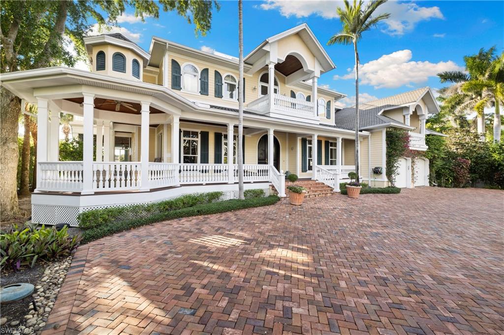 2170 Marina Drive Naples, FL 34102 - Photo 8 of 48 a front view of a building with garden and tall trees