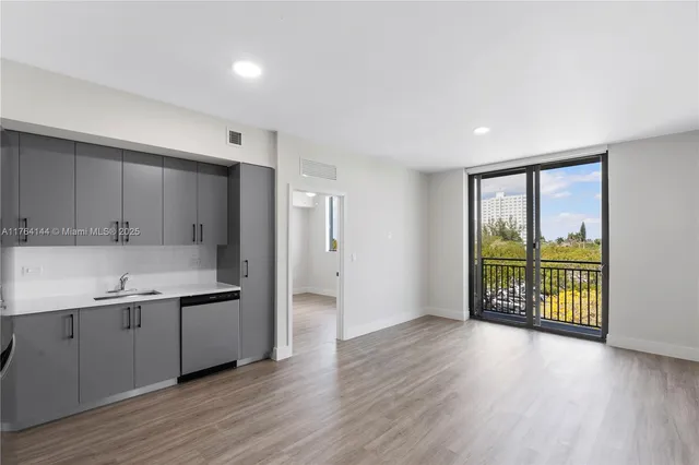 a kitchen with stainless steel appliances granite countertop a refrigerator a sink and a large window