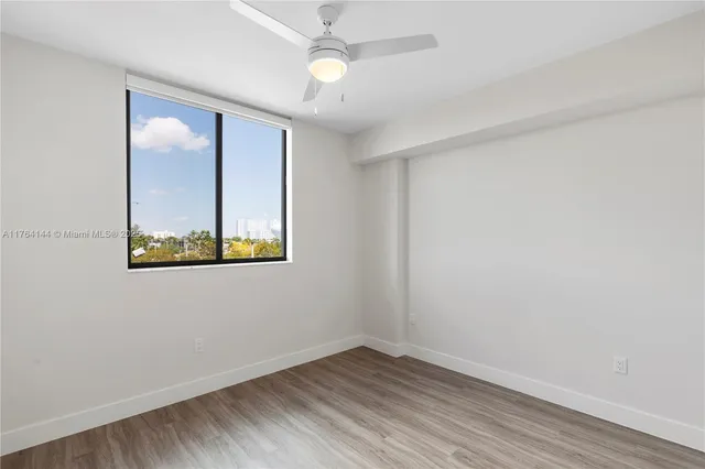 an empty room with a window and wooden floor