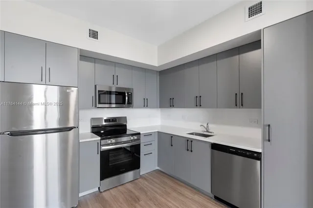 a kitchen with a sink stainless steel appliances and cabinets