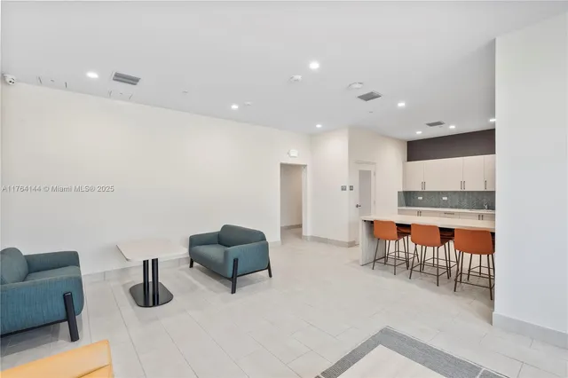 a kitchen with stainless steel appliances kitchen island granite countertop a table and chairs in it