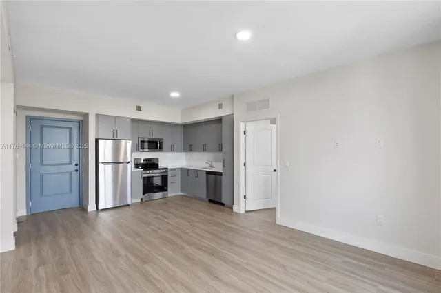 a kitchen with stainless steel appliances a refrigerator and a stove top oven