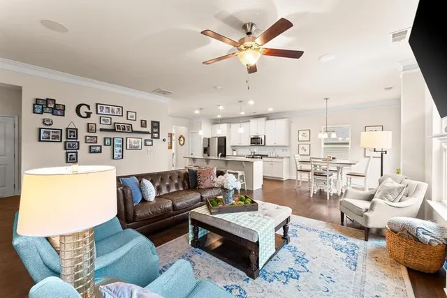 a living room with furniture kitchen view and a chandelier
