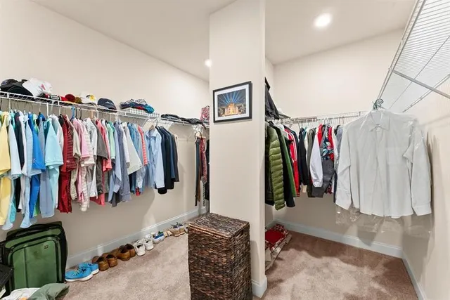 a view of walk in closet with clothes and shoes