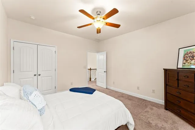 a bedroom with a large bed and a ceiling fan
