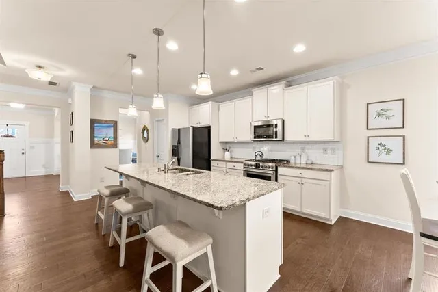 a kitchen with stainless steel appliances granite countertop a stove refrigerator sink and microwave