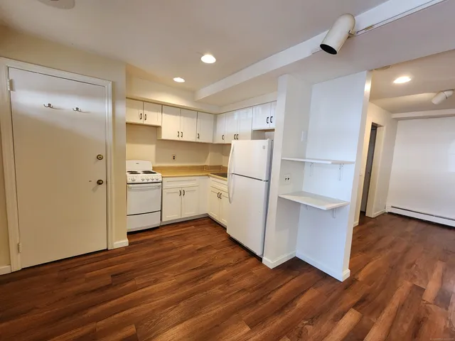 a view of a kitchen with wooden floor and electronic appliances