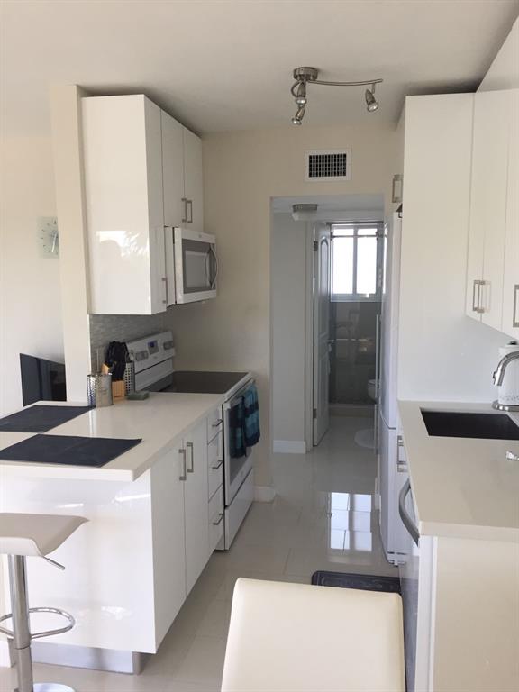 1705 North Riverside Drive, Unit 8 Pompano Beach, FL 33062 - Photo 17 of 40 a kitchen with a sink a stove and refrigerator
