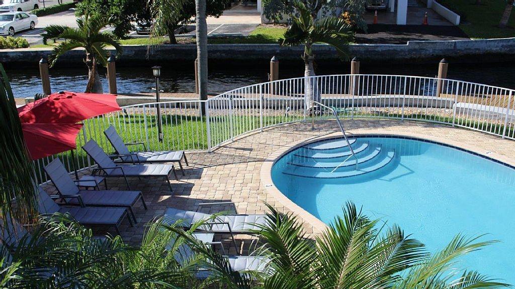 1705 North Riverside Drive, Unit 8 Pompano Beach, FL 33062 - Photo 24 of 40 a view of a chair and tables in the patio in front of house