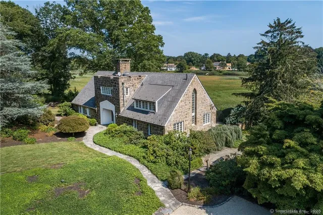 an aerial view of a house with outdoor space and trees all around