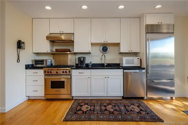 a kitchen with stainless steel appliances granite countertop a stove a refrigerator and a stove