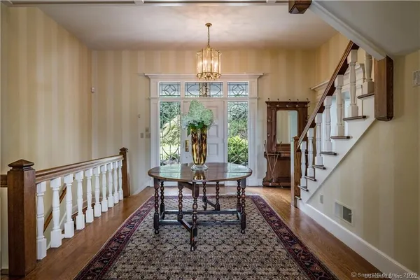 a view of a hallway with furniture and chandelier