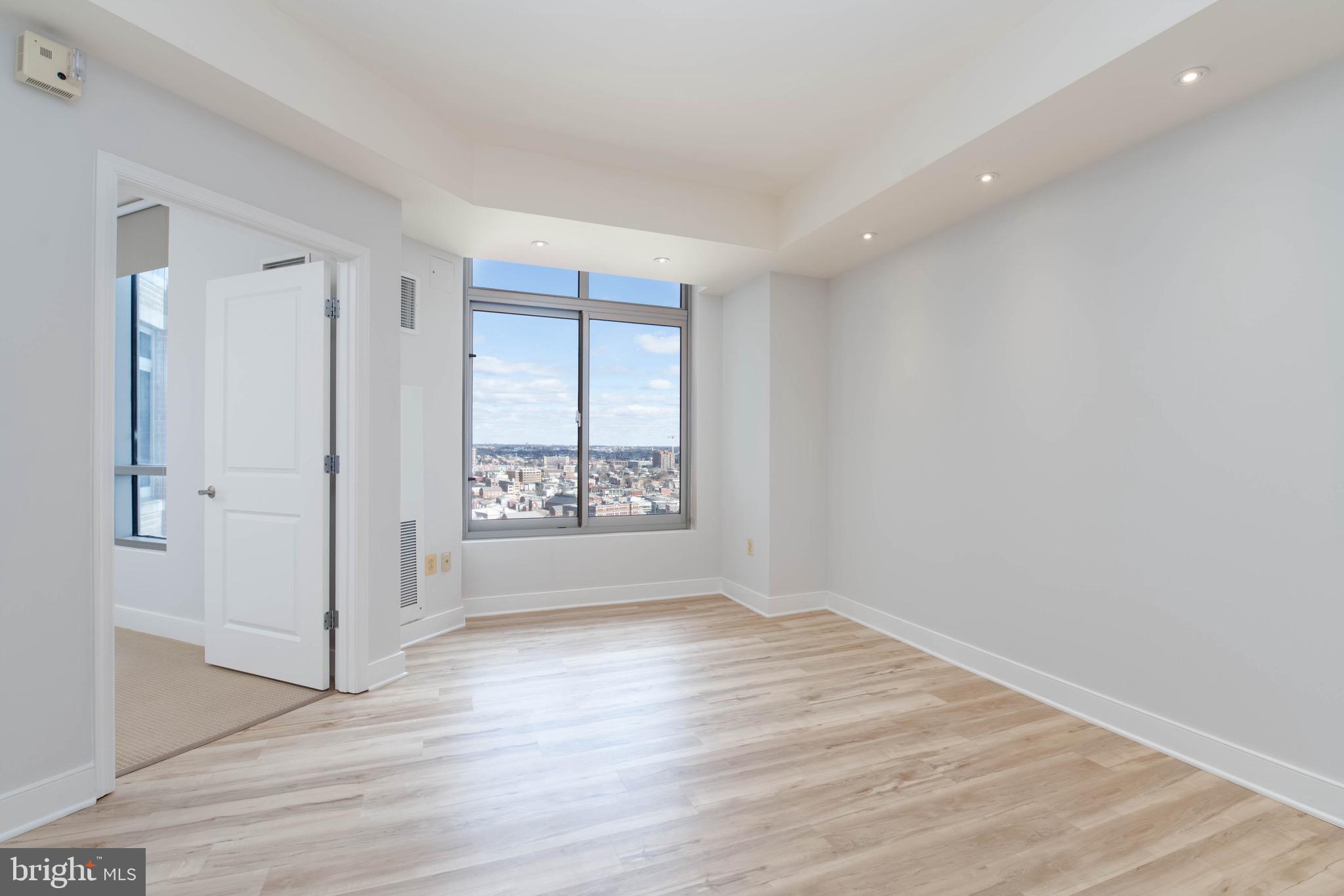 675 President Street, Unit 2207 Baltimore, MD 21202 - Photo 11 of 30 a view of an empty room with wooden floor and a window