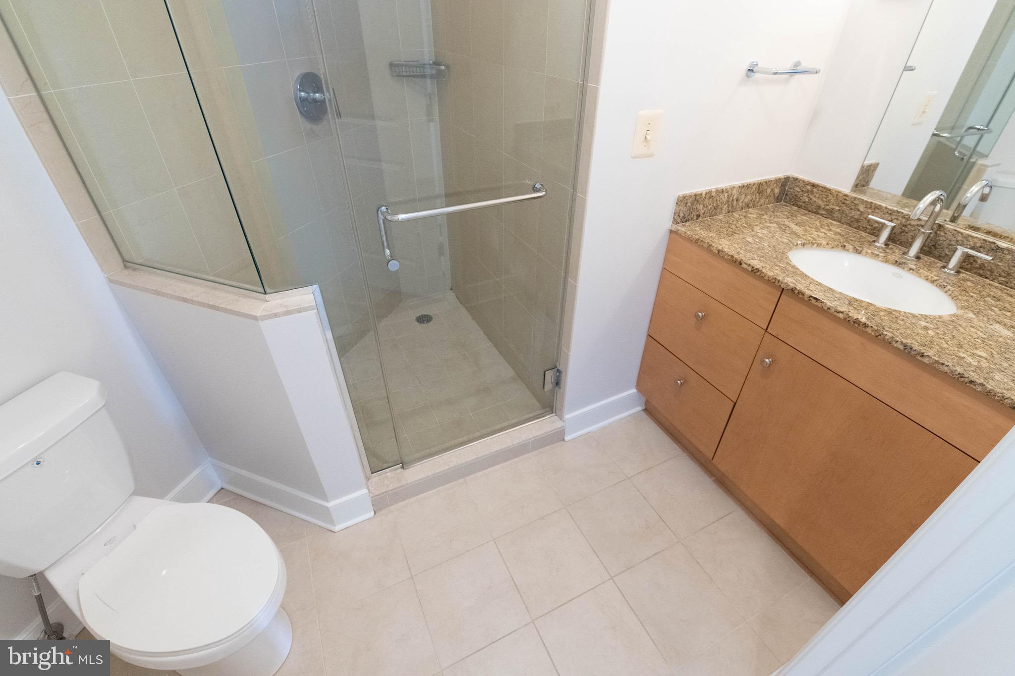 675 President Street, Unit 2207 Baltimore, MD 21202 - Photo 17 of 30 a bathroom with a granite countertop sink toilet and shower