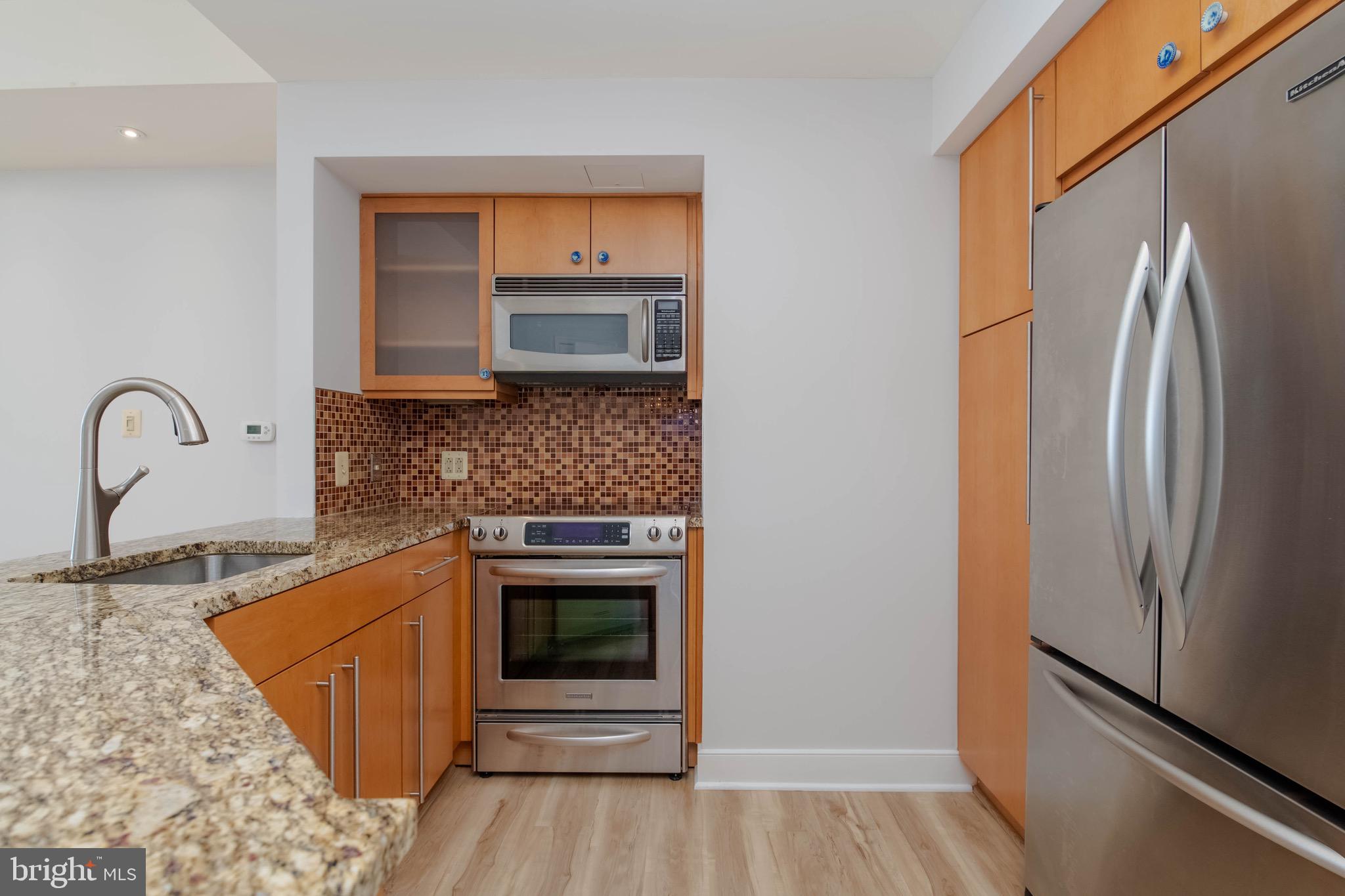 675 President Street, Unit 2207 Baltimore, MD 21202 - Photo 6 of 30 a kitchen with granite countertop a refrigerator and a stove