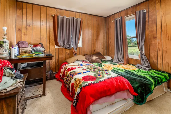 a bed sitting in a bedroom next to a window
