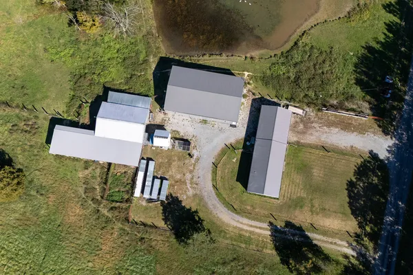 an aerial view of a house with swimming pool and a yard