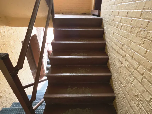 a view of staircase with white walls and railing