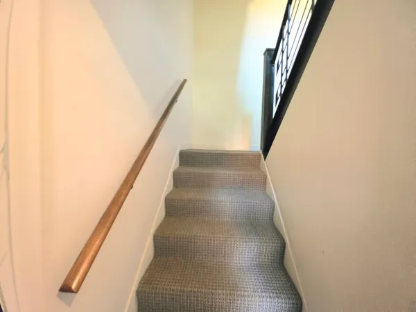 a view of a hallway with wooden floor and stairs