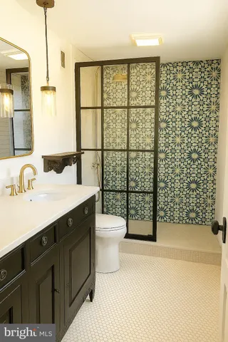 a bathroom with a granite countertop sink toilet a mirror and shower