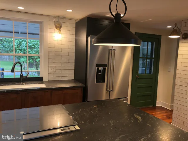 a kitchen with stainless steel appliances granite countertop a refrigerator and a sink