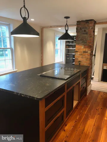 a kitchen with stainless steel appliances granite countertop a sink a stove and a wooden floors