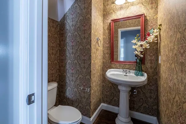 a bathroom with a toilet sink and mirror