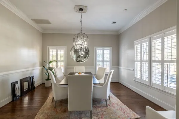 a view of a dining room with furniture a chandelier and wooden floor
