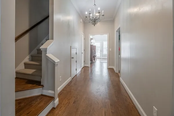 a view of a hallway with wooden floor and staircase
