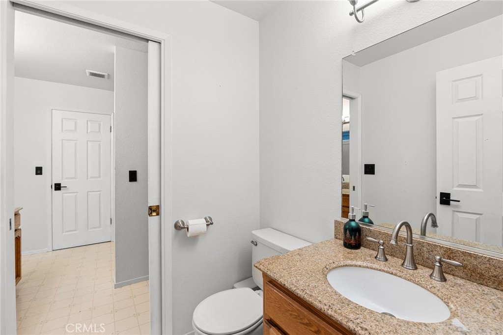 83 Gopher Road Oroville, CA 95966 - Photo 26 of 69 a bathroom with a granite countertop sink toilet a mirror a vanity and shower